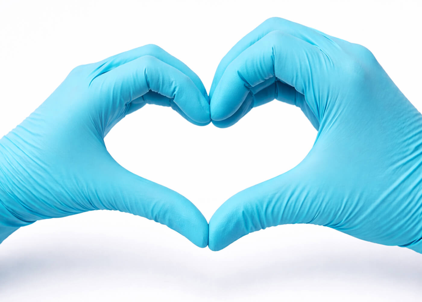 Zwei Hände mit blauen medizinischen Handschuhen formen ein Herzsymbol auf weißem Hintergrund.