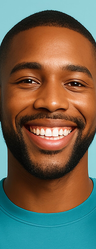 Mann mit kurzem Bart und freundlichem Lächeln vor hellblauem Hintergrund.