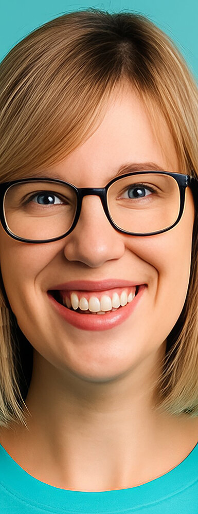 Porträt einer jungen Frau mit Blonden Haaren und Brille und freundlichem Lächeln vor hellblauem Hintergrund.
