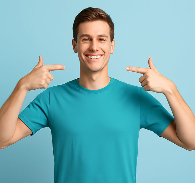 Lächelnde Person zeigt mit beiden Händen auf ihre Zähne, hellblauer Hintergrund.